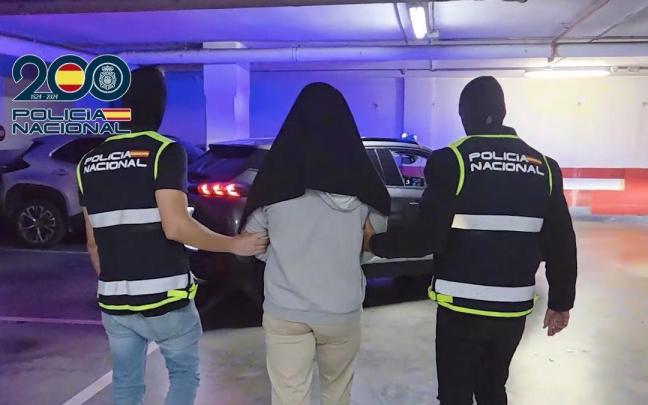 Dos agentes de la Policía Nacional con una persona detenida por su presunta vinculación al terrorismo yihadista.