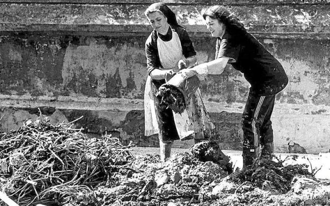 Una religiosa y una mujer colaboran en las tareas de limpieza tras la riada.