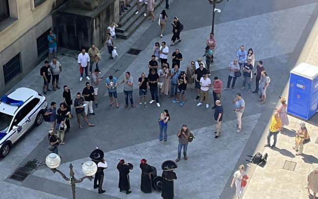 Cuatro mariachis junto a un grupo de ertzainas y curiosos frente a Sabin Etxea.