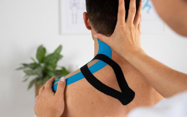 Un hombre con un vendaje neuromuscular. Un hombre con un vendaje neuromuscular.