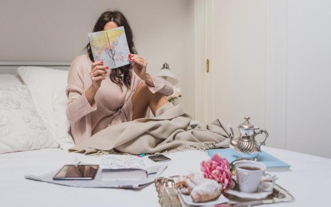 Una mujer desayuna en la cama.