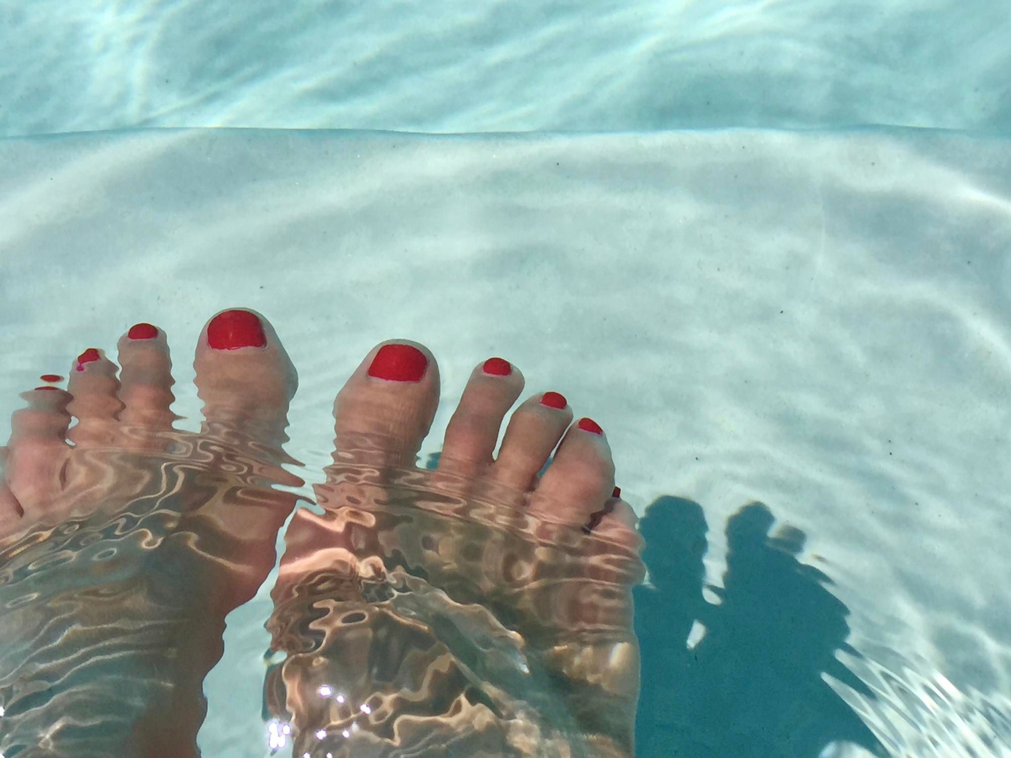 Unos pies en una piscina.