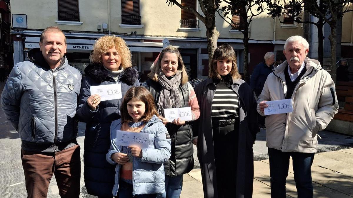 Los agraciados en el sorteo posan con los vales de compra por valor de 100 euros