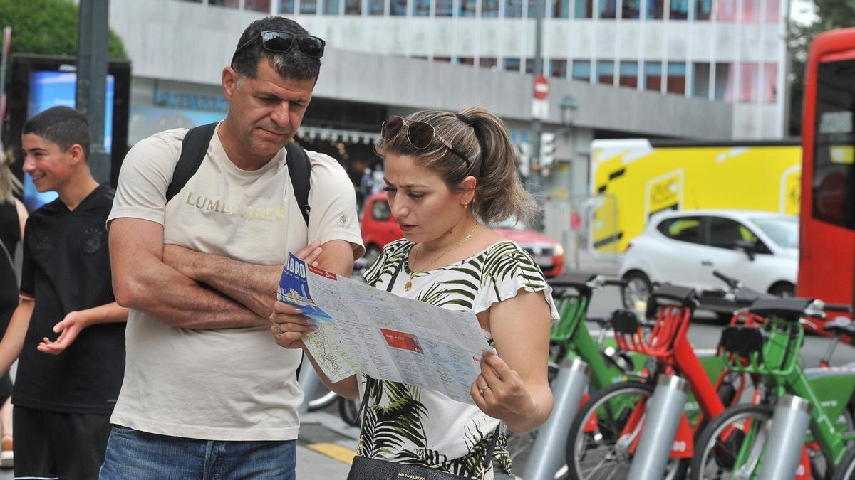 Dos turistas ojean un mapa en la plaza Circular.