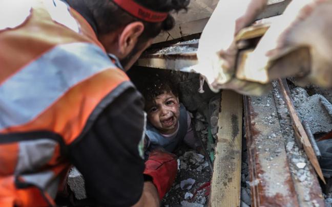 Una niña es rescatada de entre los escombros tras un bombardeo israelí sobre Gaza.