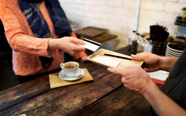 Una mujer paga la cuenta en un restaurante. / Freepik Una mujer paga la cuenta en un restaurante.