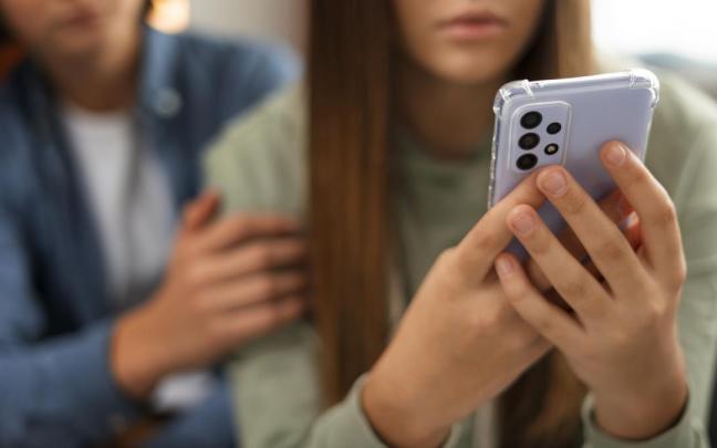 Dos jóvenes con un teléfono.