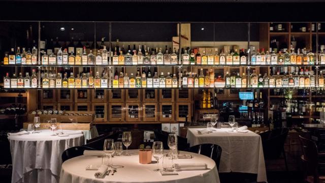 La sala, con una exhibición de botellas en las paredes.