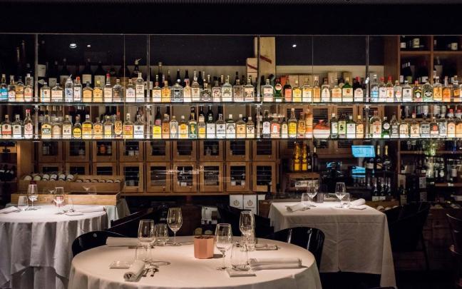 La sala, con una exhibición de botellas en las paredes.