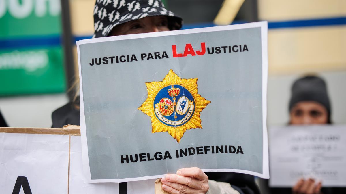 Una mujer sujeta una pancarta de 'Justicia para LAJusticia' a las puertas de la sede del Ministerio