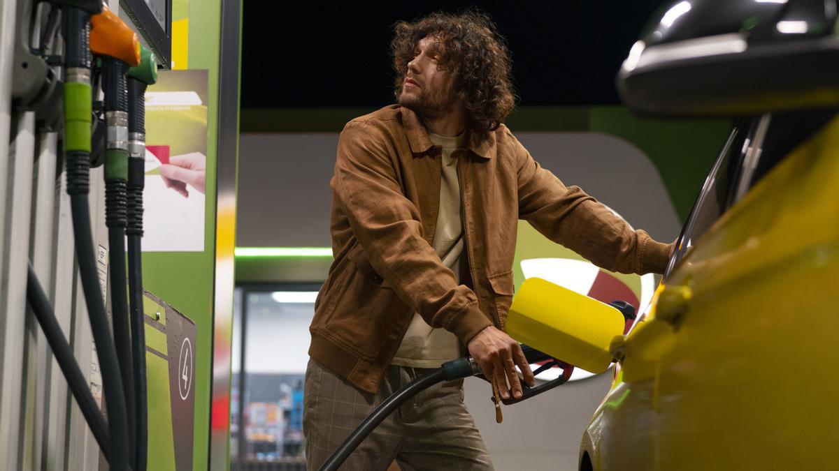 Un hombre llena su vehículo de gasolina.
