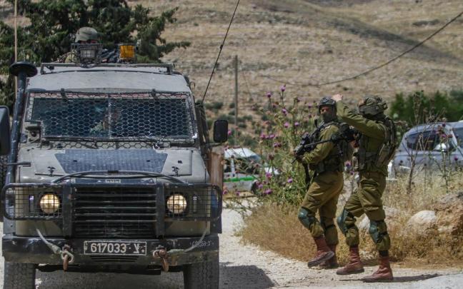 Varios soldados y un vehículo del Ejercito de Israel.