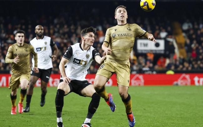 Olasagasti intenta controlar un balón aéreo ante la presión de Pepelu, en el partido disputado ayer en Mestalla. EFE / ANA ESCOBAR