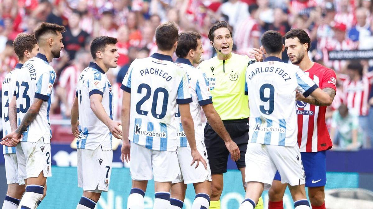 Los jugadores realistas protestan al colegiado Munuera Montero la señalización del penalti que supuso la derrota de la Real por 2-1 en el Metropolitano. / EUROPA PRESS