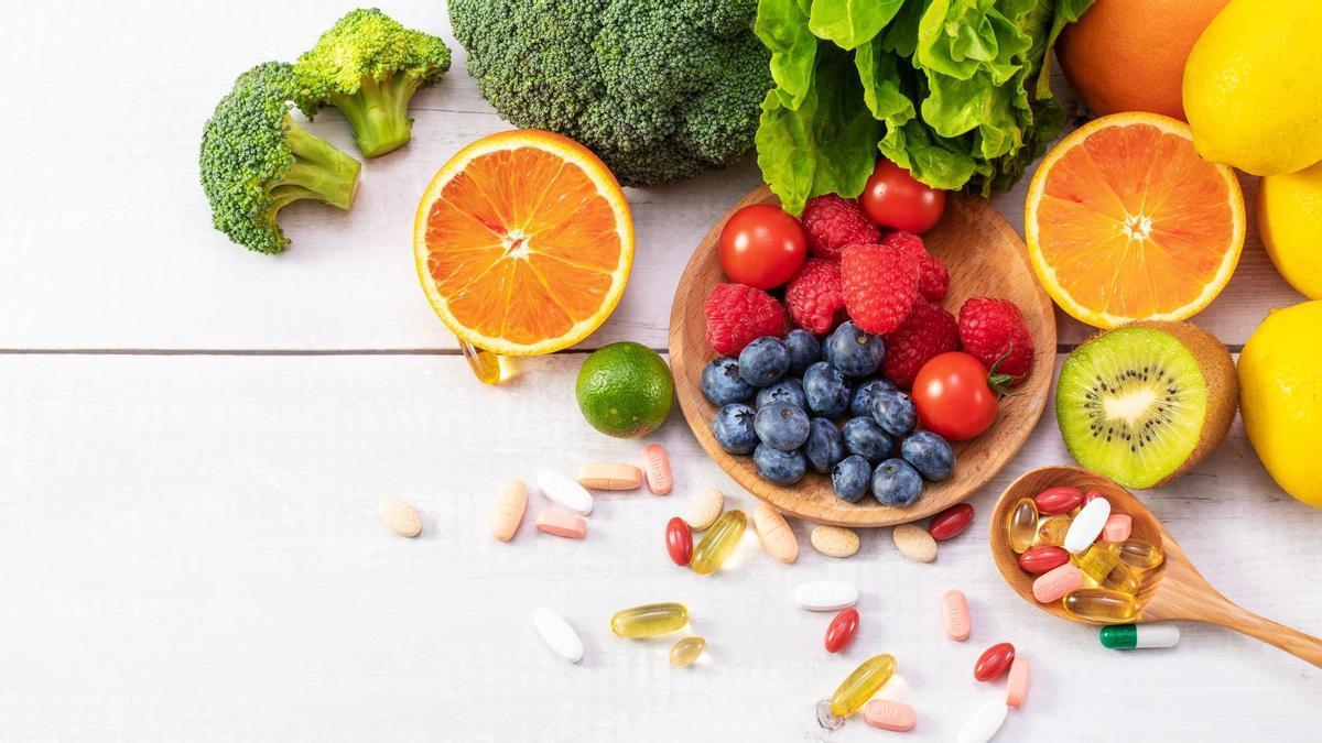 Frutas y verduras frescas junto a un puñado de medicamentos.