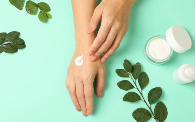 Una mujer se aplica crema hidratante en las manos. Una mujer se aplica crema hidratante en las manos.