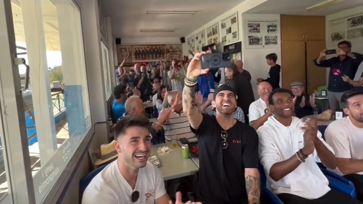 Jugadores, técnicos y aficionados del Andratx, siguiendo el sorteo en el bar del campo de Sa Plana. / N.G.