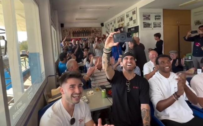 Jugadores, técnicos y aficionados del Andratx, siguiendo el sorteo en el bar del campo de Sa Plana. / N.G.