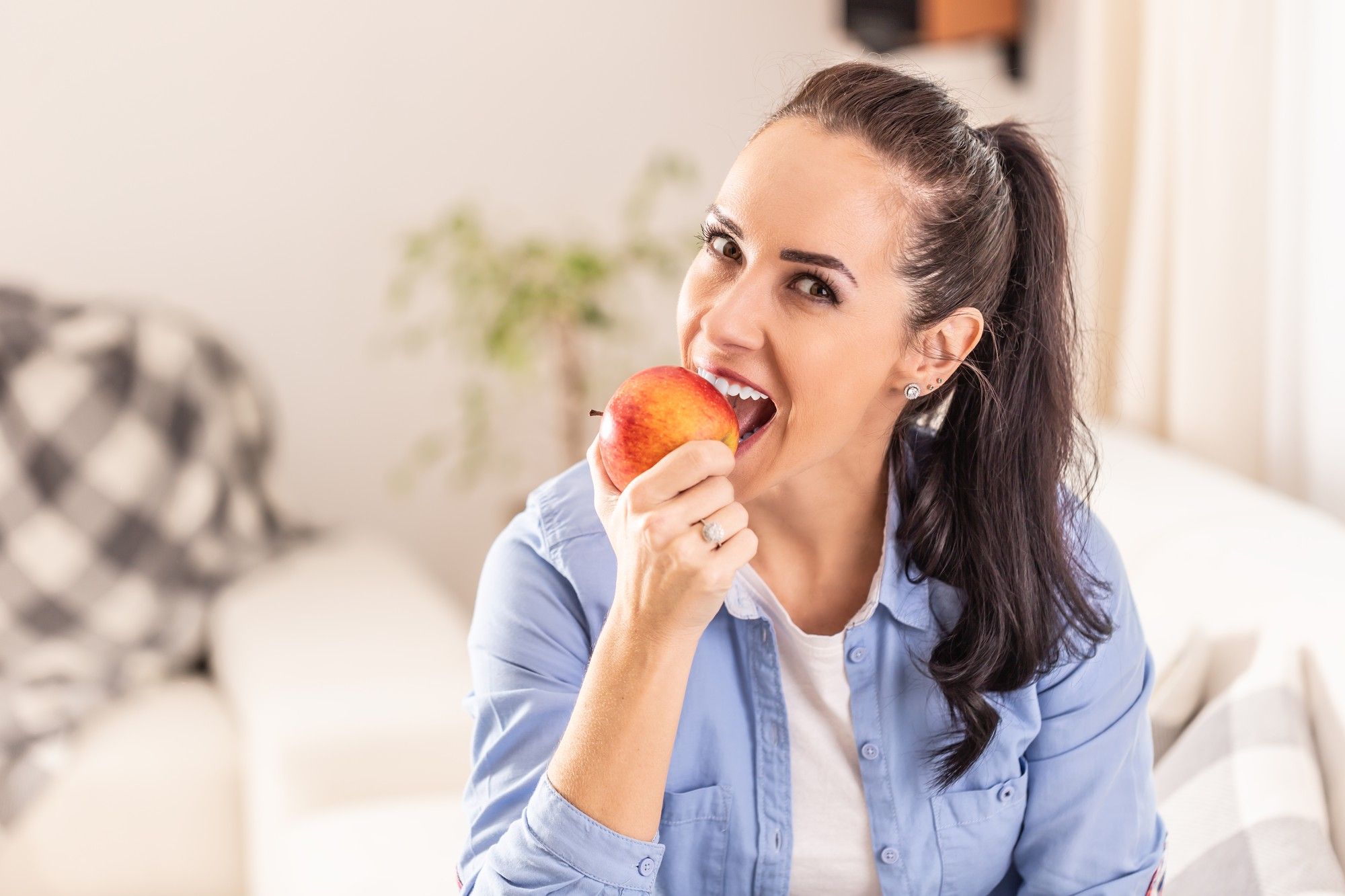 Una mujer da un mordisco a una manzana.