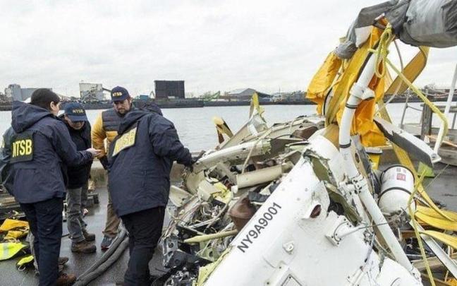 Inviestigadores examinan restos del helicóptero siniestrado en el río Hudson.