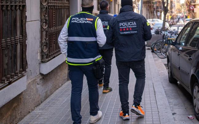 Un agente de los Mossos d'Esquadra y otro de la Policía Nacional durante un operativo policial.
