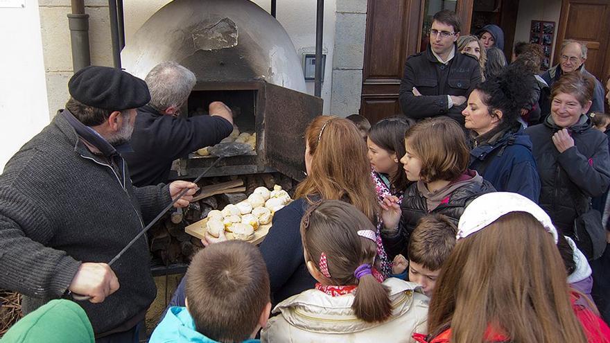 Extrayendo los txoripaes del horno de leña listos para comer en una anterior edición