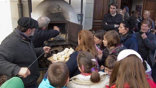 Extrayendo los txoripaes del horno de leña listos para comer en una anterior edición