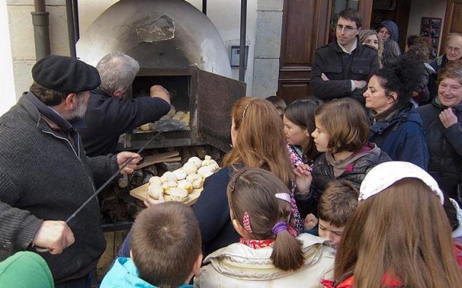Extrayendo los txoripaes del horno de leña listos para comer en una anterior edición