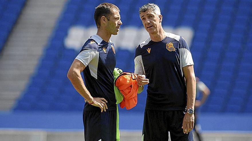 Imanol Alguacil conversa con su ayudante Mikel Labaka, durante el entrenamiento que llevó a cabo la primera plantilla txuri-urdin este pasado lunes en el estadio de Anoeta. / PEDRO MARTÍNEZ