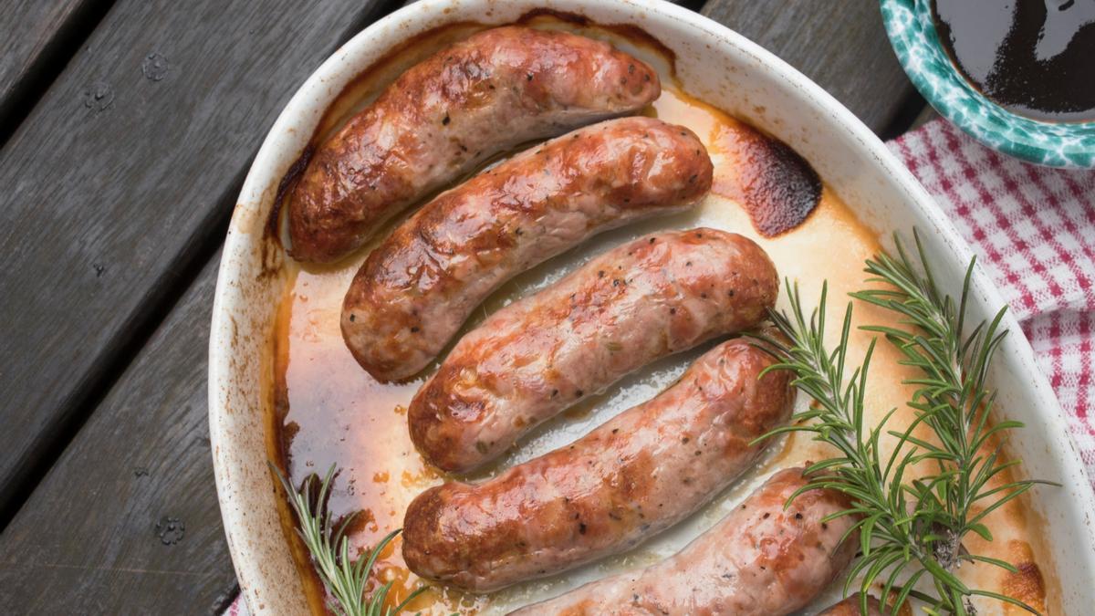 Una fuente con salchichas asadas y romero.