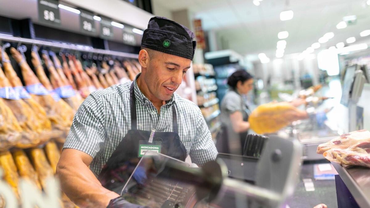 Un trabajador atendiendo a clientes en la charcutería de Mercadona.