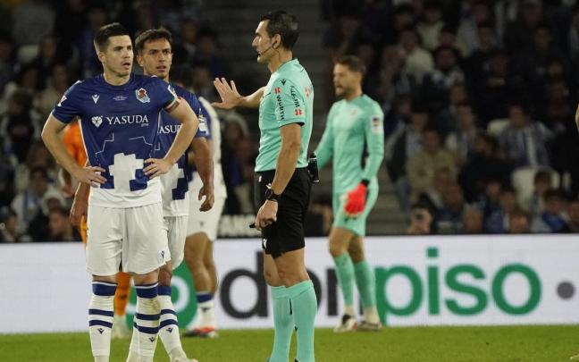 Martínez Munuera escucha las indicaciones de Hernández Hernández, ante las miradas de Zubeldia y Zubimendi. / RUBEN PLAZA