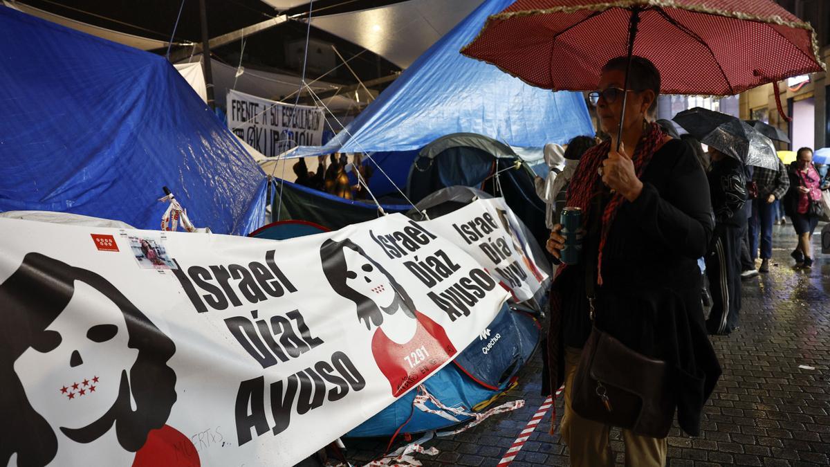 Acampada de Sol con una pancarta de Ayuso.