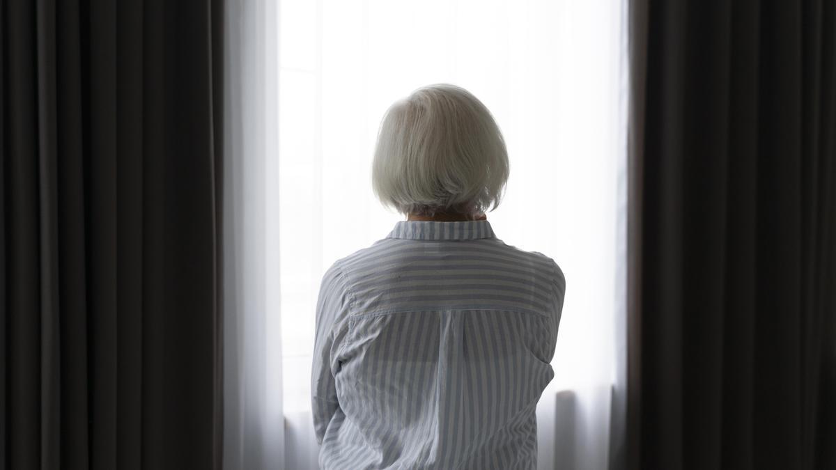 Una mujer sentada frente a la ventana.