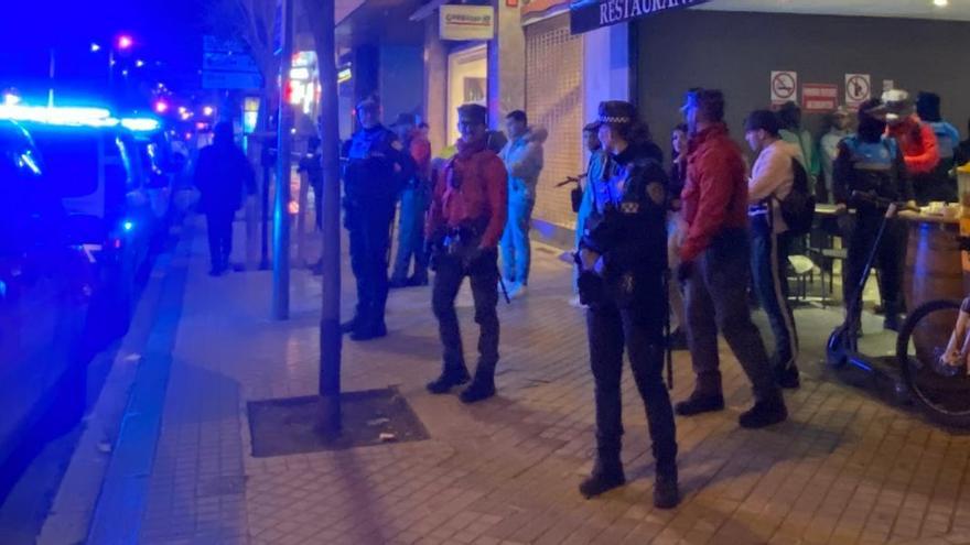 Policías municipales y forales custodian la entrada al bar durante la redada.