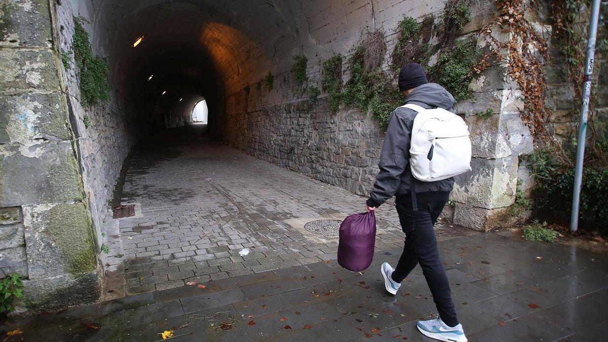 Joven inmigrante caminando hacia el túnel en el que suele pasar la noche.