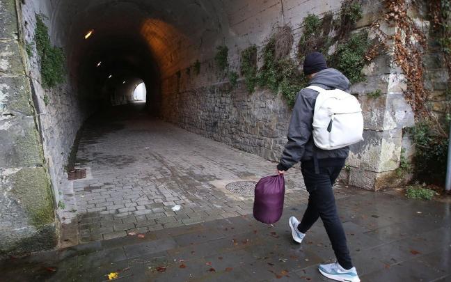 Joven inmigrante caminando hacia el túnel en el que suele pasar la noche.