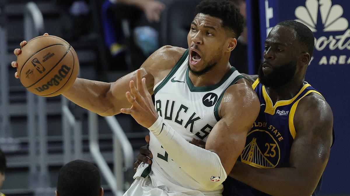 Giannis Antetokounmpo lucha con Draymond Green.