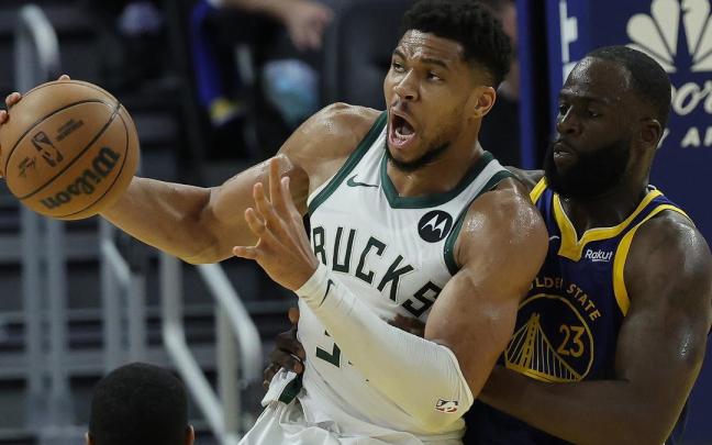 Giannis Antetokounmpo lucha con Draymond Green.
