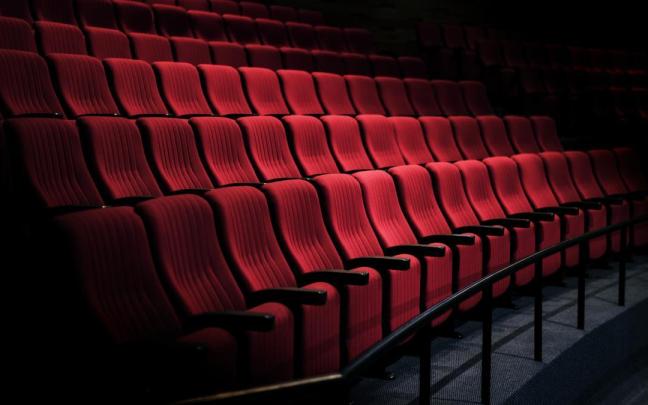 Filas de asientos vacíos en un teatro.