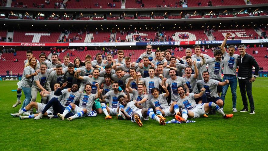 Jugadores y cuerpo técnico de la Real posan con camisetas que celebraban la clasificación para la Champions. / N.G.