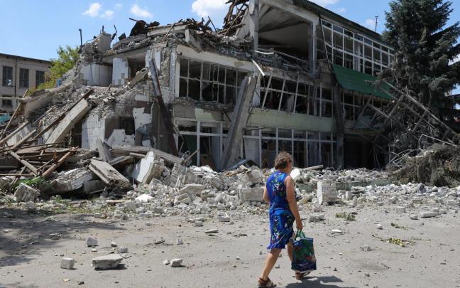 Una mujer pasa junto a un edificio destruido en Lugansk, en una imagen de archivo.