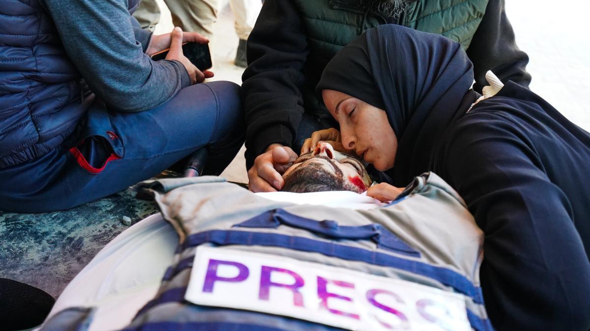 Una mujer reza junto al cadáver del periodista, Mohamed Wishah, asesinado por Israel en Gaza.