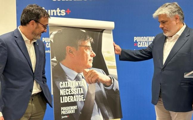 Josep Rius y Albert Batet enseñan el cartel electoral de Puigdemont.