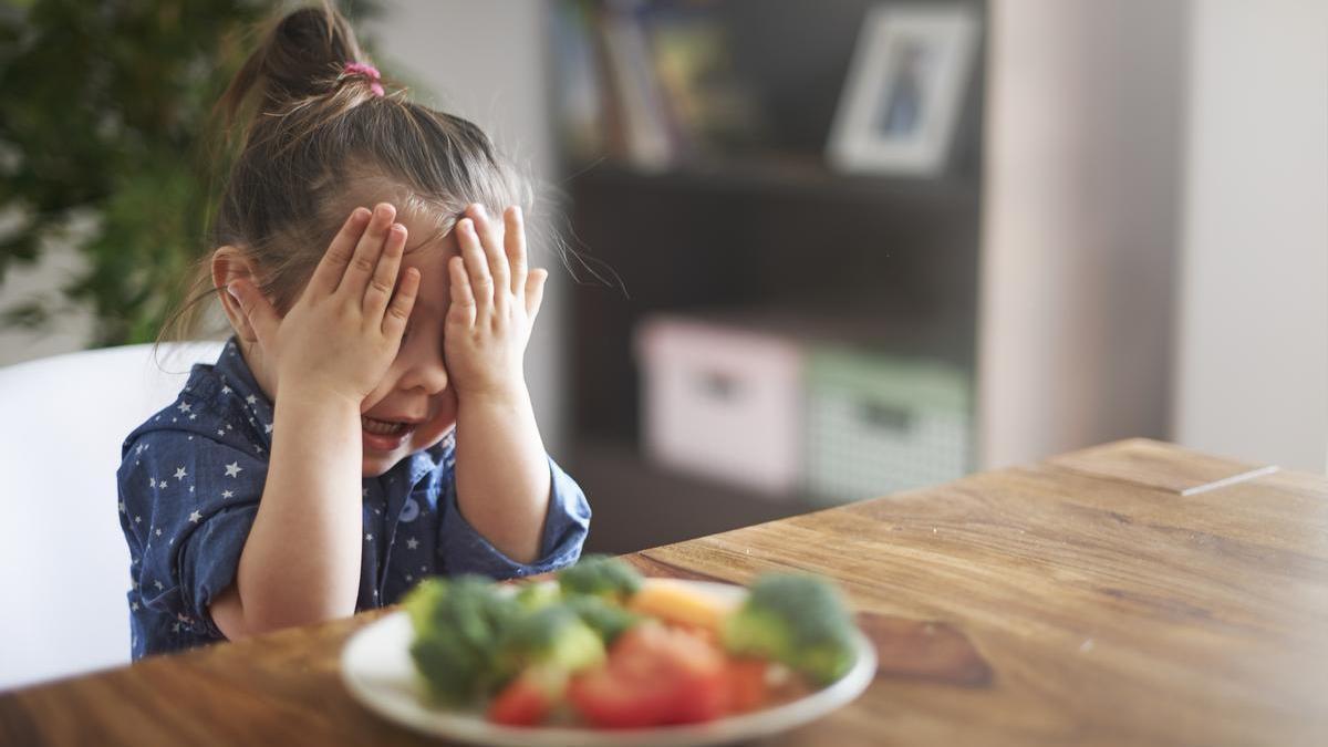 Niña no quiere comer verduras.