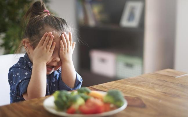 Niña no quiere comer verduras.