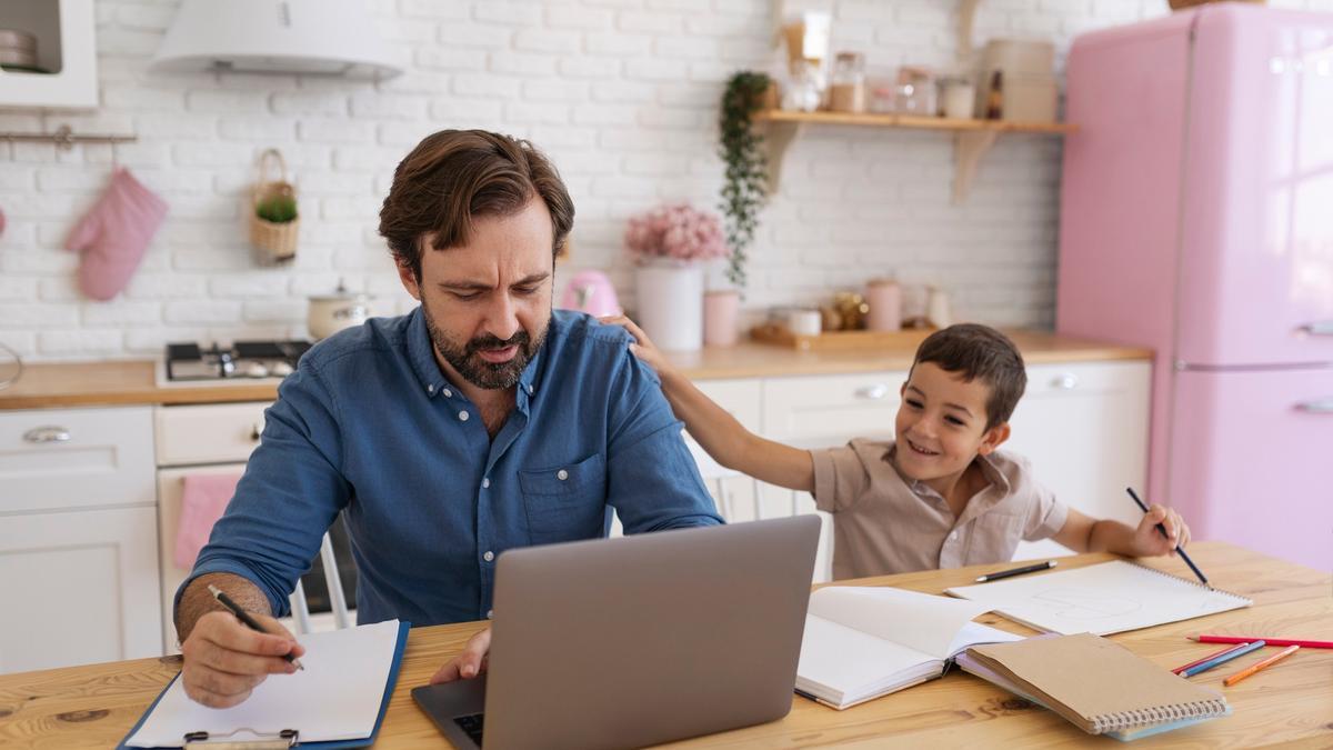 Un niño pinta junto a su padre mientras este trabaja en casa.