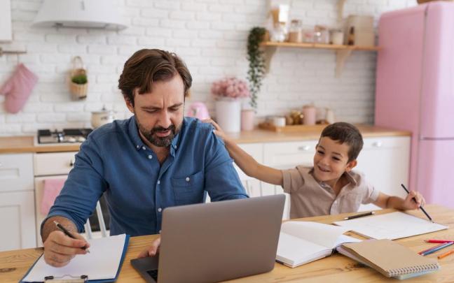 Un niño pinta junto a su padre mientras este trabaja en casa.