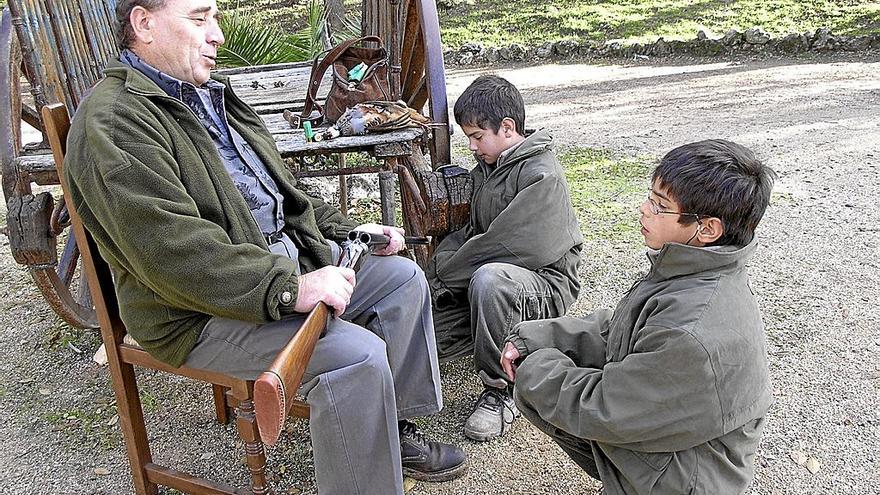 Un abuelo enseñando a sus nietos el cuidado que hay que tener con las armas.