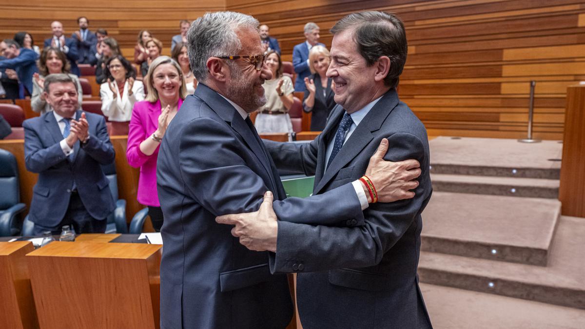 El presidente de la Junta de Castilla y León, Alfonso Fernández Mañueco (d), es felicitado por el vicepresidente de la Junta de Castilla y León, Carlos Pollán, tras ser investido para un tercer mandato